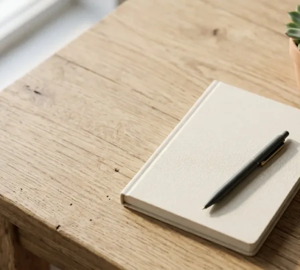 Carnet de santé ouvert posé sur une table, stylo à proximité, lumière naturelle douce, prêt pour la notation quotidienne des symptômes